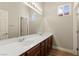 Bathroom featuring a double sink vanity with wood cabinets, a large mirror, and ample lighting at 10348 Hawks Wing St, Las Vegas, NV 89178