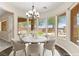 Bright dining area with modern chandelier, large windows and backyard views at 10348 Hawks Wing St, Las Vegas, NV 89178