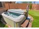 Backyard showcasing a hot tub with integrated steps, surrounded by green space and a putting green at 10348 Hawks Wing St, Las Vegas, NV 89178