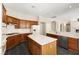 Open kitchen with center island, white countertops, wood cabinets, stainless steel appliances, and neutral color scheme at 10348 Hawks Wing St, Las Vegas, NV 89178