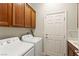 Laundry room with wood cabinets, a utility sink, and a washer and dryer at 10348 Hawks Wing St, Las Vegas, NV 89178