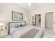 Comfortable staged bedroom with carpet, ensuite access, and modern furniture at 10348 Hawks Wing St, Las Vegas, NV 89178