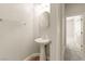 Charming powder room featuring a pedestal sink and decorative mirror and light fixture at 10348 Hawks Wing St, Las Vegas, NV 89178