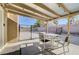 Relaxing covered patio with outdoor seating and views of the fenced backyard at 1708 Anzio St, Las Vegas, NV 89108