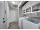 Bright laundry room featuring a washer, dryer, shelving, and wood-look flooring at 1708 Anzio St, Las Vegas, NV 89108