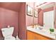 Powder room with pink walls, decorative mirror and modern vanity at 262 Cielito Lindo St, Henderson, NV 89012