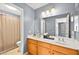 Bright bathroom featuring double sinks, a large mirror, and wood cabinets at 262 Cielito Lindo St, Henderson, NV 89012