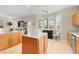 Open kitchen with light wood cabinets, stainless steel appliances, granite countertops, a dining area, and a view of the backyard at 262 Cielito Lindo St, Henderson, NV 89012