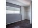 A small bedroom with wood floor and a large window shows a closet with shelving at 2721 Merritt Ave, Las Vegas, NV 89102