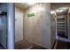 Hallway with wood paneling, a storage closet and a 