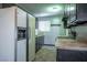 Functional kitchen with black cabinets, a white refrigerator, and a window above the sink at 2721 Merritt Ave, Las Vegas, NV 89102