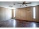 Spacious living room with wood paneling, hardwood floors and natural light from large windows at 2721 Merritt Ave, Las Vegas, NV 89102