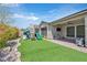 Beautiful backyard featuring artificial turf, a playground, and a covered patio with outdoor kitchen at 2931 Raywood Ash Dr, Las Vegas, NV 89138