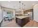 Open-concept kitchen featuring a granite island, stainless appliances, and adjacent dining area with sliding glass doors at 2931 Raywood Ash Dr, Las Vegas, NV 89138