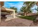 Inviting backyard featuring a covered patio, desert landscaping, and lush green lawn at 3005 Dotted Wren Ave, North Las Vegas, NV 89084