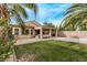 Spacious backyard with well-maintained grass, covered patio, and mature palm trees at 3005 Dotted Wren Ave, North Las Vegas, NV 89084