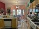 Open kitchen featuring tile floors, yellow cabinetry, and white appliances with a view to dining area at 3028 Ripon Dr, Las Vegas, NV 89134