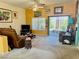 Cozy living room with carpet floors, sliding glass doors, and an assortment of decorative wall art at 3028 Ripon Dr, Las Vegas, NV 89134