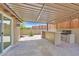Outdoor covered patio with stone floor, built in grill, bar seating and private fence at 3101 Greenbriar Dr, Las Vegas, NV 89121