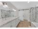 Modern bathroom with dual sinks, granite countertops, soaking tub and a glass shower at 3101 Greenbriar Dr, Las Vegas, NV 89121