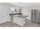 Bright kitchen features stainless steel refrigerator, gray cabinets, light walls and wood-look flooring at 3101 Greenbriar Dr, Las Vegas, NV 89121