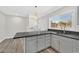 Updated kitchen with gray cabinets, stylish countertops, stainless steel sink, and a view to the laundry area at 3101 Greenbriar Dr, Las Vegas, NV 89121