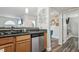 Kitchen featuring stainless steel dishwasher, wood cabinetry, and a view of the connecting rooms at 3145 E Flamingo Rd # 1045, Las Vegas, NV 89121