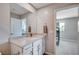 Bathroom with a large mirror, white cabinets, and view into the bedroom at 3358 Via Strada St, Henderson, NV 89044