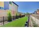 A well-maintained, fenced dog run area with artificial turf offers a secure and pleasant space for pets to play at 3358 Via Strada St, Henderson, NV 89044