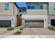 Modern two-story home with a gray garage door, a brick driveway, and colorful front door at 3358 Via Strada St, Henderson, NV 89044