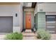 Close-up of the home's entry with a modern orange door, green accents, and a brick entry at 3358 Via Strada St, Henderson, NV 89044