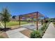 A community pavilion with seating provides a shaded area for relaxation, surrounded by a green lawn and landscaped grounds at 3358 Via Strada St, Henderson, NV 89044