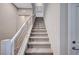 Staircase with carpeted steps and modern metal railing leading to the upper level at 3358 Via Strada St, Henderson, NV 89044