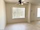 Comfortable living room features neutral tile, ceiling fan and natural light filtering through large windows at 4338 Caliente St # 12, Las Vegas, NV 89119