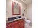 Bathroom featuring a vanity with cherry wood cabinetry, black granite, and a framed mirror at 4575 Dean Martin Dr # 1112, Las Vegas, NV 89103