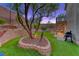 Serene backyard featuring a mature tree, landscaped terraces, an outdoor kitchen, and access to a private pool at 53 Precipice Ct, Henderson, NV 89002