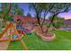 Charming backyard with a playground, mature trees, and lush greenery, perfect for Gathering fun at 53 Precipice Ct, Henderson, NV 89002
