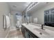 Bright bathroom with a double sink vanity, large mirror, and shower-tub combo with stylish blue and white curtains at 53 Precipice Ct, Henderson, NV 89002