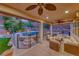 Inviting covered patio with comfortable seating, a ceiling fan, and stunning views of the pool and landscape at 53 Precipice Ct, Henderson, NV 89002