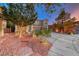 Charming home with mature trees, rock landscaping, and a long driveway leading to a two-car garage at 53 Precipice Ct, Henderson, NV 89002