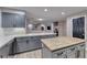 Spacious kitchen with gray cabinets, kitchen island, and an open view to the living area at 53 Precipice Ct, Henderson, NV 89002