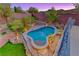 Stunning pool area with a unique design, surrounded by lush landscaping, hardscape, and stone accents at 53 Precipice Ct, Henderson, NV 89002