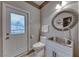 Charming powder room featuring a unique round mirror, stylish sink, and convenient access to the outdoors at 53 Precipice Ct, Henderson, NV 89002