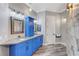 Bathroom with stylish blue cabinets, dual sinks, decorative mirrors and lighting at 5913 Audria Falls Ave, Las Vegas, NV 89131