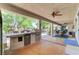 Covered patio with outdoor kitchen, bar seating, and views of the pool and lush landscaping at 5913 Audria Falls Ave, Las Vegas, NV 89131