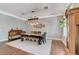 Elegant dining room featuring a live edge wood table, bench and six upholstered chairs under a unique light fixture at 5913 Audria Falls Ave, Las Vegas, NV 89131
