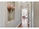 Hallway leading to a bedroom with hardwood floors and decorative niche with floral arrangement at 5913 Audria Falls Ave, Las Vegas, NV 89131