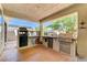 Inviting outdoor kitchen with stainless steel appliances, grill, and bar seating for entertaining guests at 5913 Audria Falls Ave, Las Vegas, NV 89131