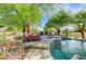 Inviting backyard pool with spa, lounge chairs, mature trees, and lush desert landscaping create a private oasis at 5913 Audria Falls Ave, Las Vegas, NV 89131