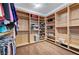 Spacious walk-in closet with custom built-in shelving and hardwood floors at 5913 Audria Falls Ave, Las Vegas, NV 89131
